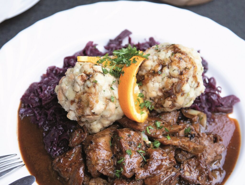 Vegansl auf dem Teller mit Knödel und Rotkraut.